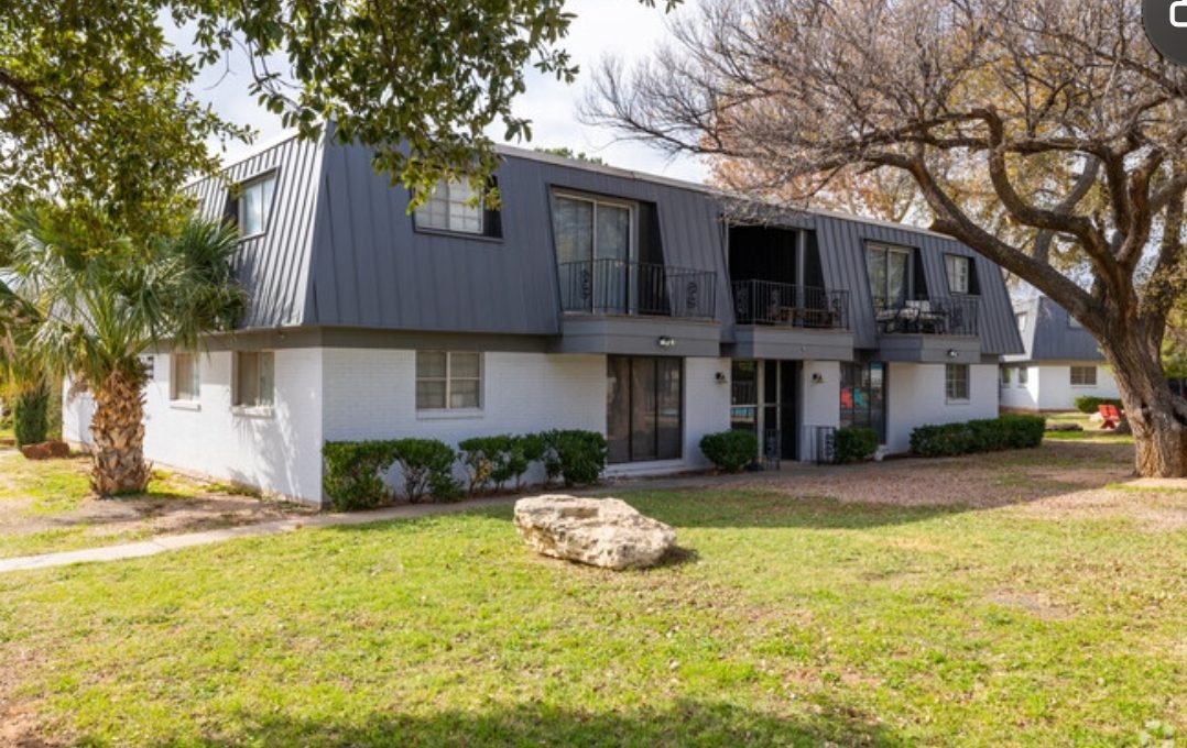 the apartment complex is located in the middle of a grassy area at The Arden Arms Apartments