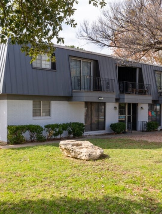 the apartment complex is located in the middle of a grassy area at The Arden Arms Apartments