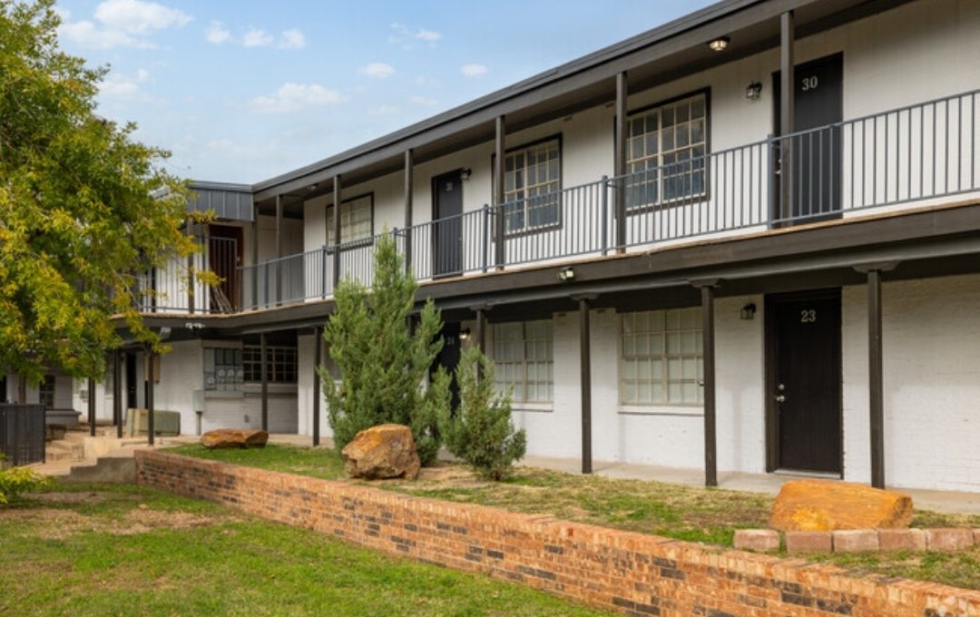 the apartment building has a large lawn and grass at The Arden Arms Apartments
