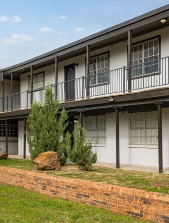 the apartment building has a large lawn and grass at The Arden Arms Apartments
